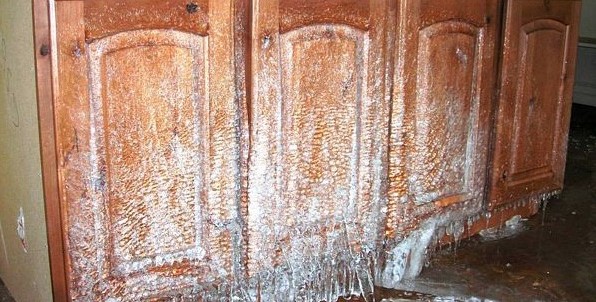 Water and ice damage on wooden cabinets.